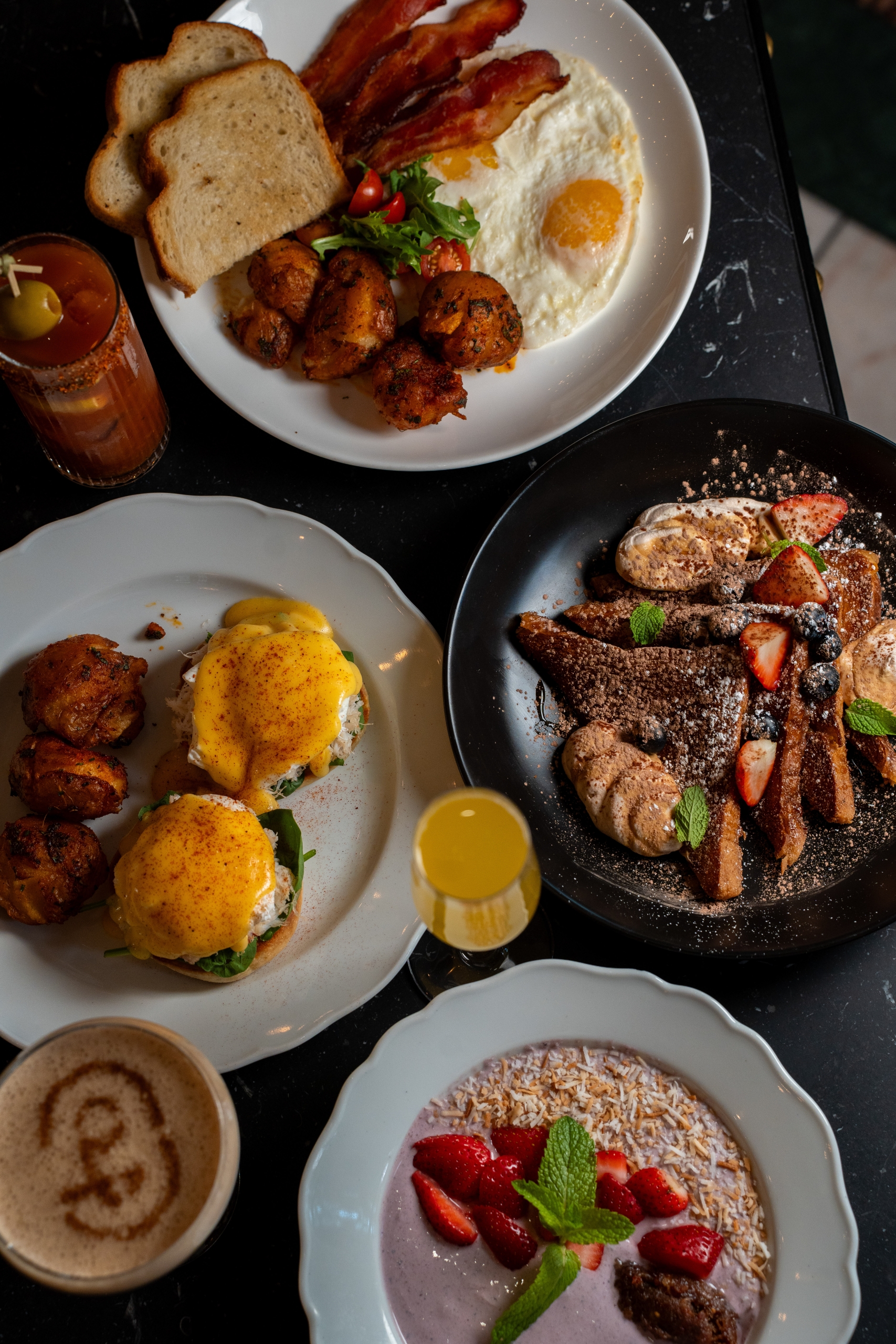 Multiple plates of breakfast food on a table