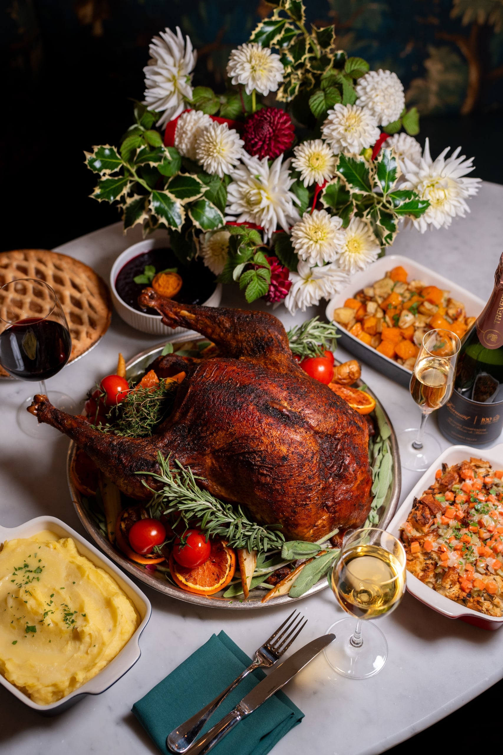 Christmas turkey dinner on white table with white flowers in a vase