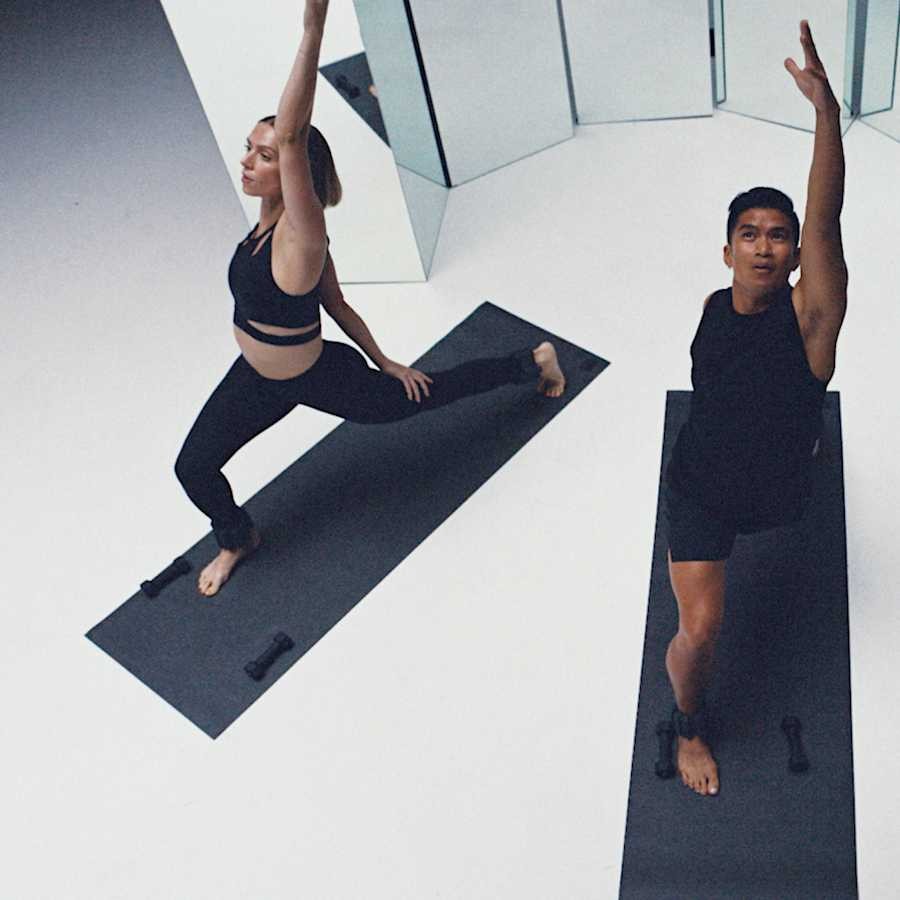A man and a woman dressed in black doing yoga